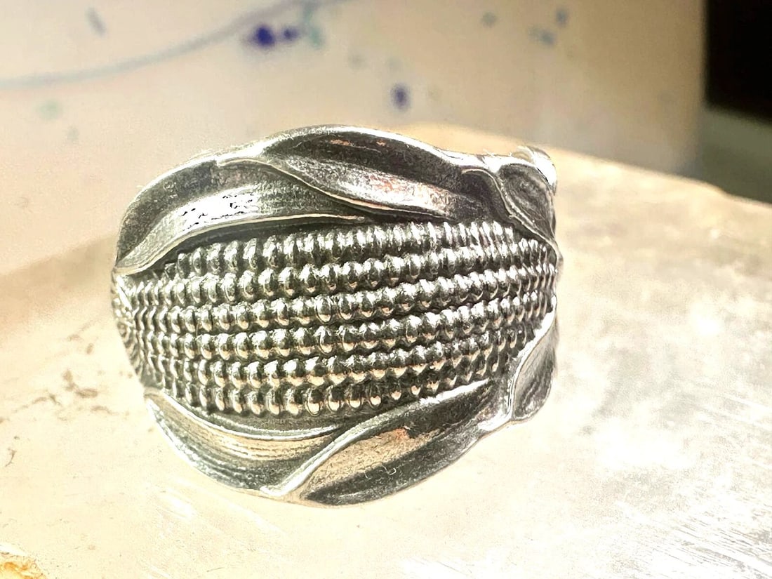 CORN SPOON RING SIZE 7 ADJUSTABLE STERLING SILVER BAND: CORN SPOON RING SIZE 7 ADJUSTABLE STERLING SILVER BAND Corn spoon ring size 7 adjustable sterling silver band Size 7 adjustable Weight 6.8g Width 5/8" Thinnest part of band. 1/8"