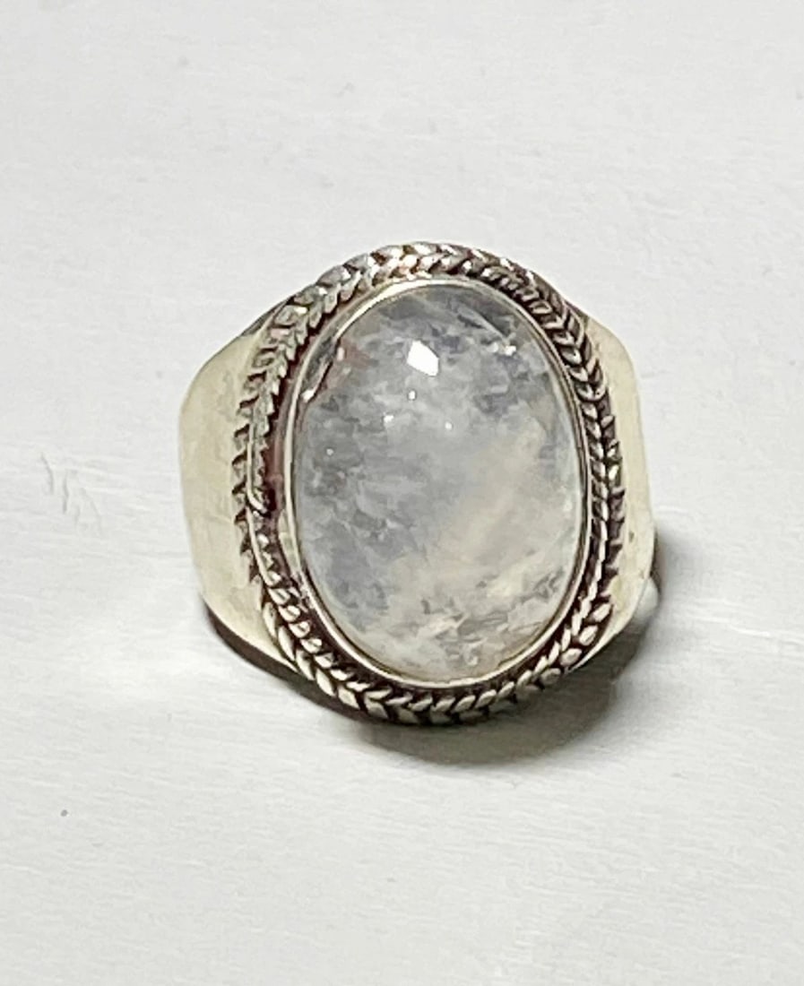 MOONSTONE RING CIGAR BAND WOMEN STERLING SILVER SIZE 7.50: MOONSTONE RING CIGAR BAND WOMEN STERLING SILVER SIZE 7.50 Moonstone ring cigar band women sterling silver An imperfection on the edge of the stone- slight chip - and setting there curves in to reflect