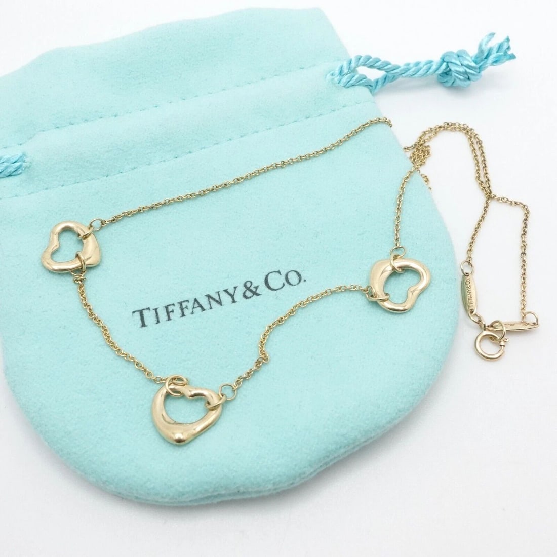 TIFFANY & CO. ELSA PERETTI 18K YELLOW GOLD OPEN HEART STATION NECKLACE 16.5": Tiffany & Co. Elsa Peretti 18K Yellow Gold Three Open Heart Station Necklace Length - 16.5" Long Chain Width - 1mm Pendant Width - 11mm Est. Retail Price - $1500 USD + Tax Total Weight - 4.9 Grams Hal