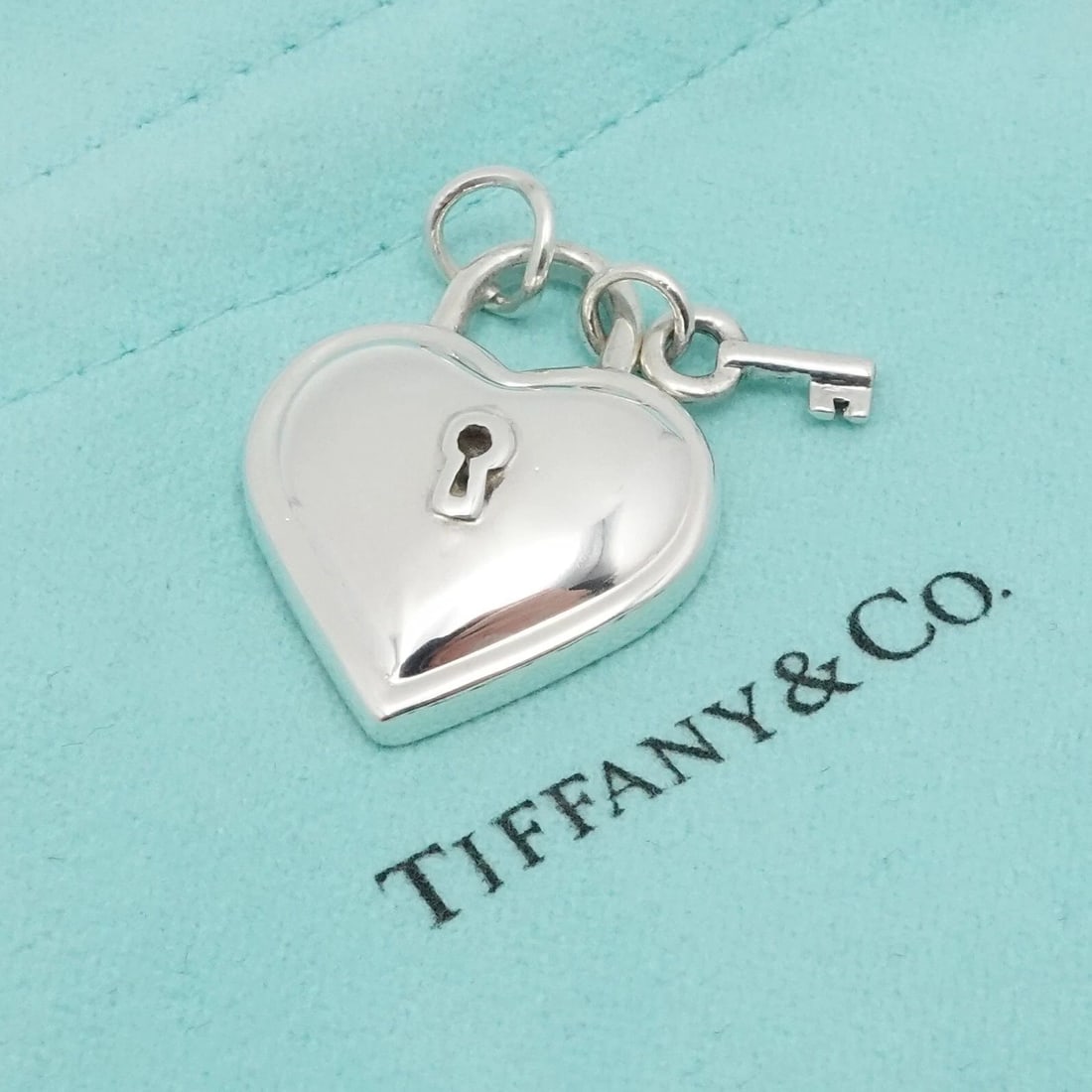 1994 TIFFANY & CO. STERLING SILVER HEART KEY PADLOCK PENDANT 1": Vintage 1994 Tiffany & Co. Sterling Silver Heart Key Padlock Pendant ONLY Height - 1" approx. Width - 0.86" Depth - 5.5mm Thick Bail Width - 5mm Total Weight - 13 Grams Hallmark - Tiffany & Co. 925 19