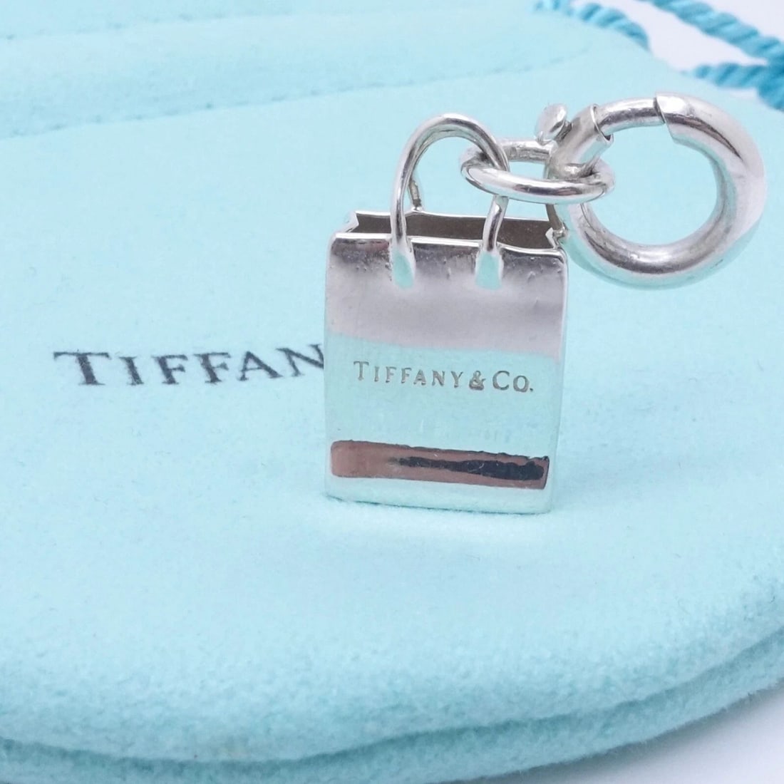 TIFFANY & CO. STERLING SILVER SHOPPING BAG CHARM: Tiffany & Co. Sterling Silver Shopping Bag Charm Height w. bail - 1.20" Width - 0.50" Weight - 3.8 Grams Est. Retail - $300 USD Looks Great & Pouch NOT Included
