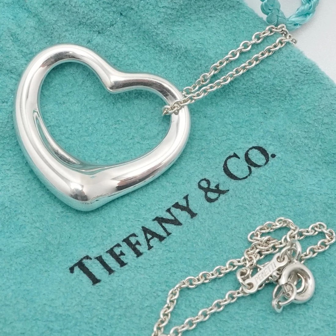 TIFFANY & CO. PERETTI STERLING SILVER 27MM OPEN HEART PENDANT NECKLACE 18" POUCH: Tiffany & Co. Elsa Peretti Sterling Silver Open Heart Medium Pendant Necklace Length - 18" Long Chain Width - 1.5mm Pendant Width - 27mm Est. Retail Price - $700 USD + Tax Total Weight - 10 Grams Hall