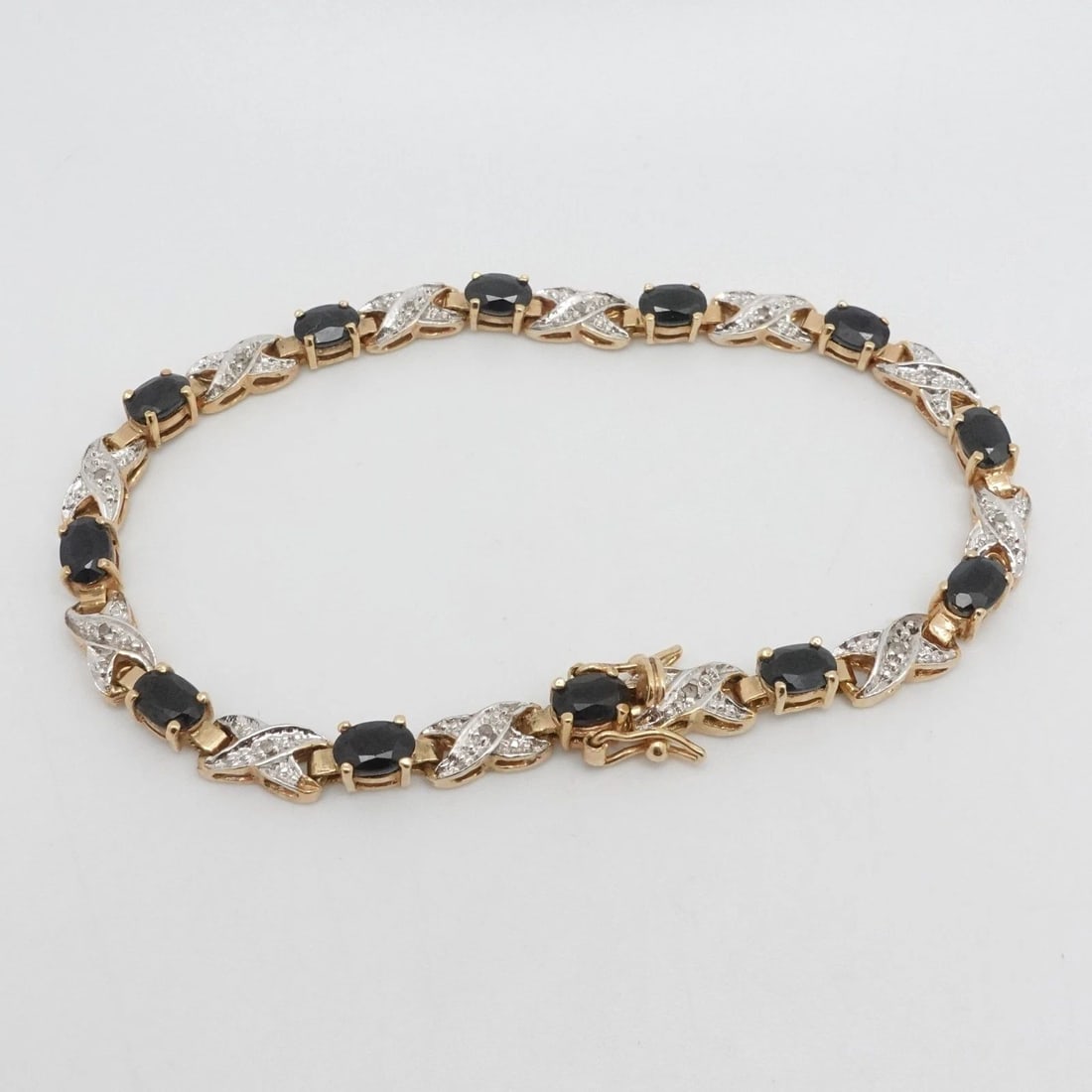 YELLOW GOLD PLATED STERLING SILVER OVAL SAPPHIRE DIAMOND TENNIS BRACELET 8" LONG: YELLOW GOLD PLATED STERLING SILVER OVAL SAPPHIRE DIAMOND TENNIS BRACELET 8" LONG Yellow Gold Plated Sterling Silver Oval Dark Blue Sapphire & Diamond Tennis Bracelet Length - 8" Long Fits up to 7.75" 
