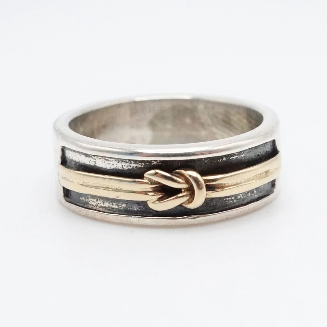STERLING SILVER 14K YELLOW GOLD 7MM KNOT BAND RING - SIZE 7.25: STERLING SILVER 14K YELLOW GOLD 7MM KNOT BAND RING - SIZE 7.25 Sterling Silver 925 14K Yellow Gold Love Knot Band Ring Size - 7.25 Band Width - 7mm Total Weight - 6.5 Grams