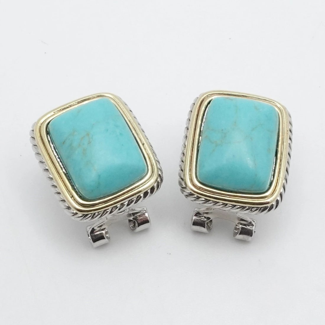 SILVER PLATED TWO TONE TURQUOISE RECTANGLE OMEGA BACK STUD EARRINGS: SILVER PLATED TWO TONE TURQUOISE RECTANGLE OMEGA BACK STUD EARRINGS Silver Plated Two Tone Turquoise Rectangle Omegaback Stud Earrings Height - 3/4" Depth - 9mm Gemstone Size - 11mm x 15mm Total Weigh