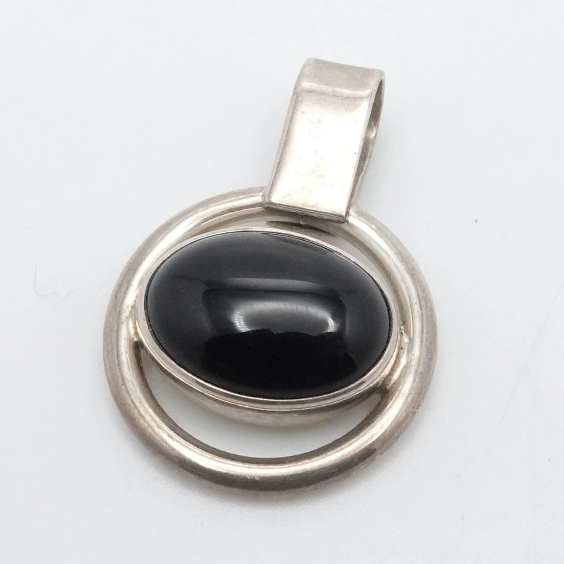 STERLING SILVER OVAL BLACK ONYX PENDANT 1.4": STERLING SILVER OVAL BLACK ONYX PENDANT 1.4" Sterling Silver Oval Black Onyx Pendant Length - 1.4" Width - 14.5mm Bail Height - 11mm Bail Width - 6mm Total Weight - 11.1 Grams