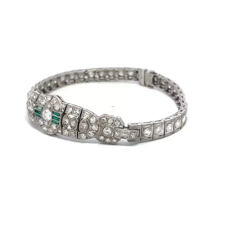 ART DECO DIAMOND PLATINUM BRACELET FANCY CENTERPIECE MILGRAIN STYLE: ART DECO DIAMOND PLATINUM BRACELET FANCY CENTERPIECE MILGRAIN STYLE This Art Deco diamond platinum bracelet features a fancy centerpiece with a milgrain border around the diamonds and green stone. The