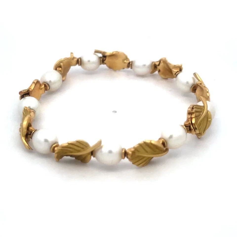 TIFFANY & CO. GOLD BRACELET 18K YELLOW OLIVE LEAF & PEARL LINK STYLE: TIFFANY & CO. GOLD BRACELET 18K YELLOW OLIVE LEAF & PEARL LINK STYLE The Tiffany & Co. Pearls Gold Bracelet is a luxurious piece of fine jewelry that features cultured white pearls set in 18k yellow g
