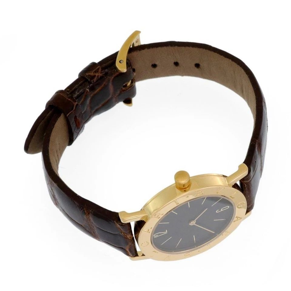 BVLGARI 18K GOLD MEN'S WATCH WITH LEATHER BAND: BVLGARI 18K GOLD MEN'S WATCH WITH LEATHER BAND BVLGARI 18K GOLD MEN'S WATCH WITH LEATHER BAND Bvlgari Engraved Bezel 18k Yellow Gold Leather Band Men's Watch Quartz Description This is an authentic me