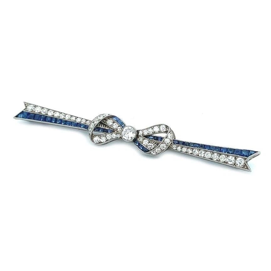 ART DECO PLATINUM DIAMOND SAPPHIRE RIBBON BOW LONG BROOCH: ART DECO PLATINUM DIAMOND SAPPHIRE RIBBON BOW LONG BROOCH ART DECO PLATINUM DIAMOND SAPPHIRE RIBBON BOW LONG BROOCH This is an elegant long ribbon bow brooch, it is crafted from platinum featuring a d