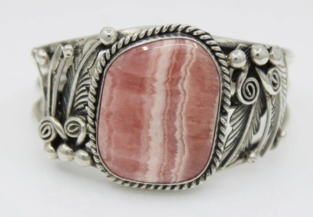 GILBERT ADAKAI STERLING SILVER NAVAJO RHODOCHROSITE CUFF BRACELET 6" - 52.6 GR: GILBERT ADAKAI STERLING SILVER NAVAJO RHODOCHROSITE CUFF BRACELET 6" - 52.6 GR Description Gilbert Adakai Sterling Silver Navajo Rhodochrosite Cuff Bracelet Bracelet is in good condition. May show sig