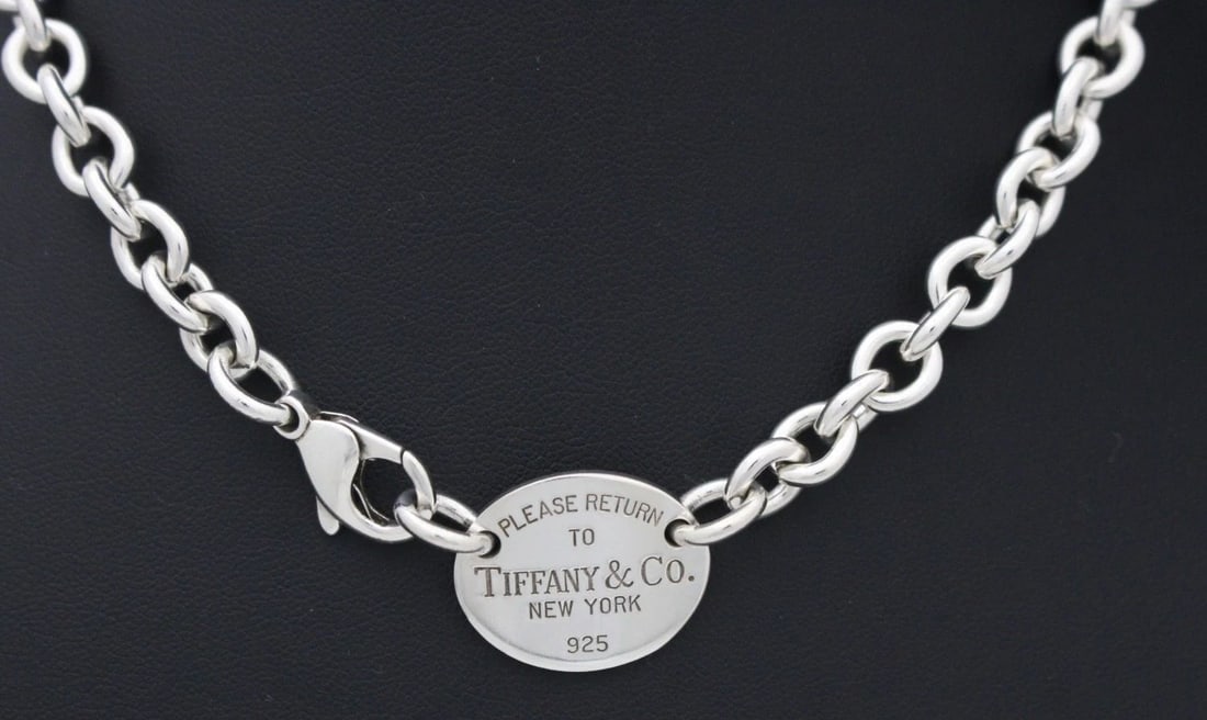 TIFFANY & CO. STERLING SILVER PLEASE RETURN OVAL TAG NECKLACE 16" W/ POUCH: TIFFANY & CO. STERLING SILVER PLEASE RETURN OVAL TAG NECKLACE 16" W/ POUCH Description Tiffany & Co. Sterling Silver Please Return Oval Tag Choker Necklace Necklace is in good condition. May show sign