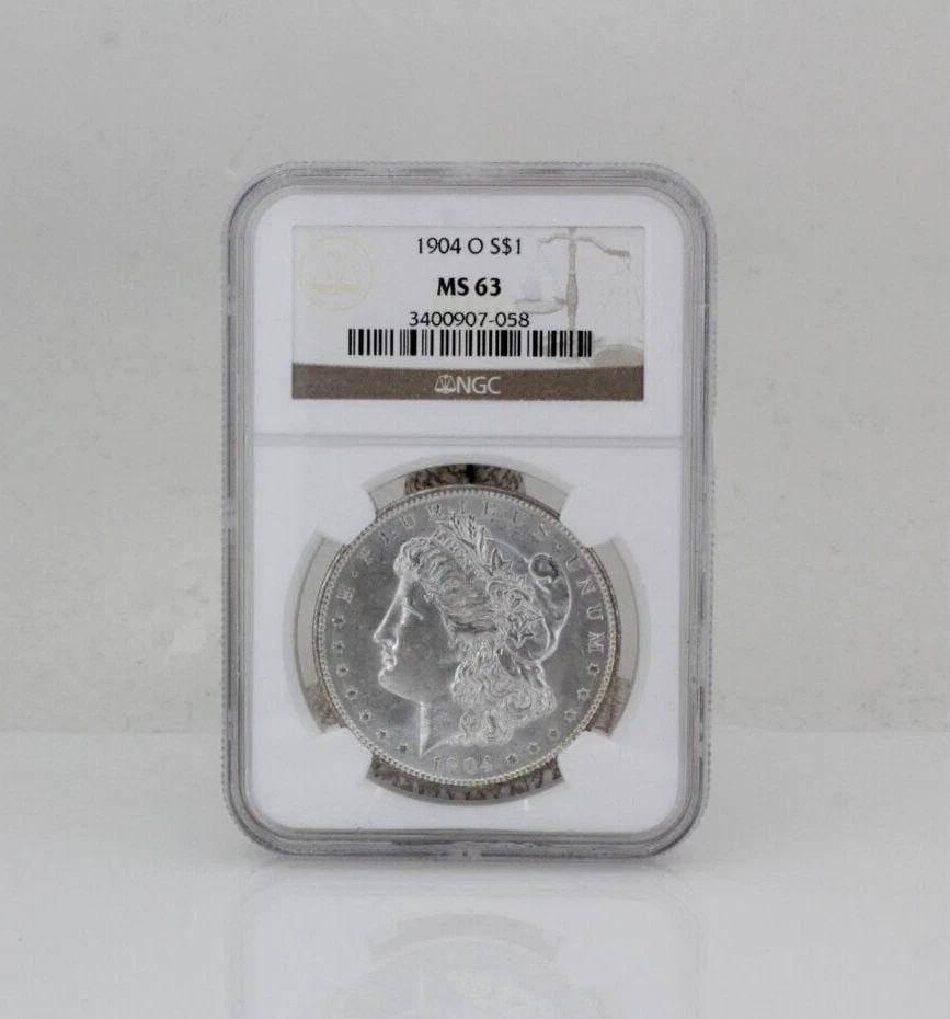 1904-O MORGAN SILVER DOLLAR $1 NGC MS63: 1904-O MORGAN SILVER DOLLAR $1 NGC MS63 Description 1904-O Morgan Silver Dollar $1 NGC MS63 Coin is in great condition. Plastic holder may show signs of wear and/or tear. The listing is for the coin o