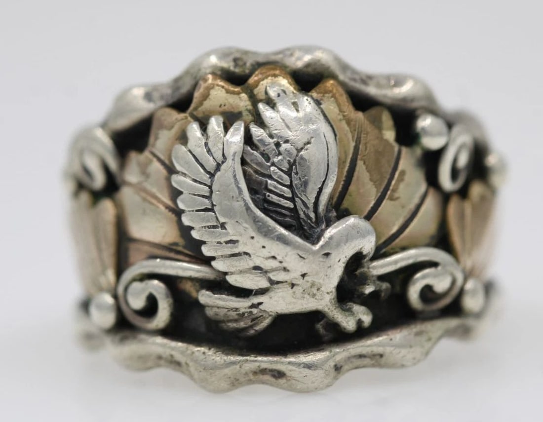 N.S.C NAVAJO STERLING SILVER & GF EAGLE BAND RING SIZE 10.5 - 9.4 GRAMS: N.S.C NAVAJO STERLING SILVER & GF EAGLE BAND RING SIZE 10.5 - 9.4 GRAMS Description N.S.C Navajo Sterling Silver & Gold Filled Eagle Band Ring Ring is in good condition. May show signs of wear and/or 