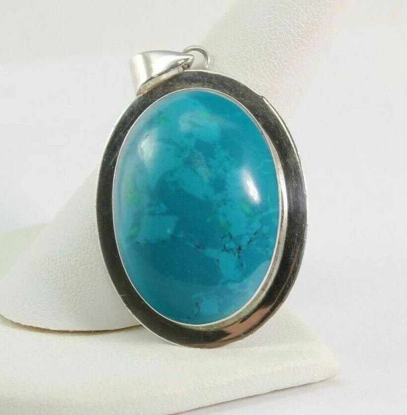 OVAL TURQUOISE & STERLING SILVER PENDANT 21 MM BY 30 MM ~ 10.4 GRAMS: OVAL TURQUOISE & STERLING SILVER PENDANT 21 MM BY 30 MM ~ 10.4 GRAMS Description Oval Turquoise & Sterling Silver Pendant Item is in great condition. May show signs of wear and/or tarnish. MEASURES AP