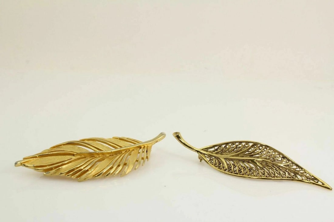 GOLD TONED AVANTE FILIGREE & JJ LEAF BROOCH PIN SET: GOLD TONED AVANTE FILIGREE & JJ LEAF BROOCH PIN SET Description GOLD TONED AVANTE FILIGREE & JJ LEAF BROOCH SET Items are in good condition. May show signs of wear and/or tarnish. SET OF 2 BOTH BROOCH