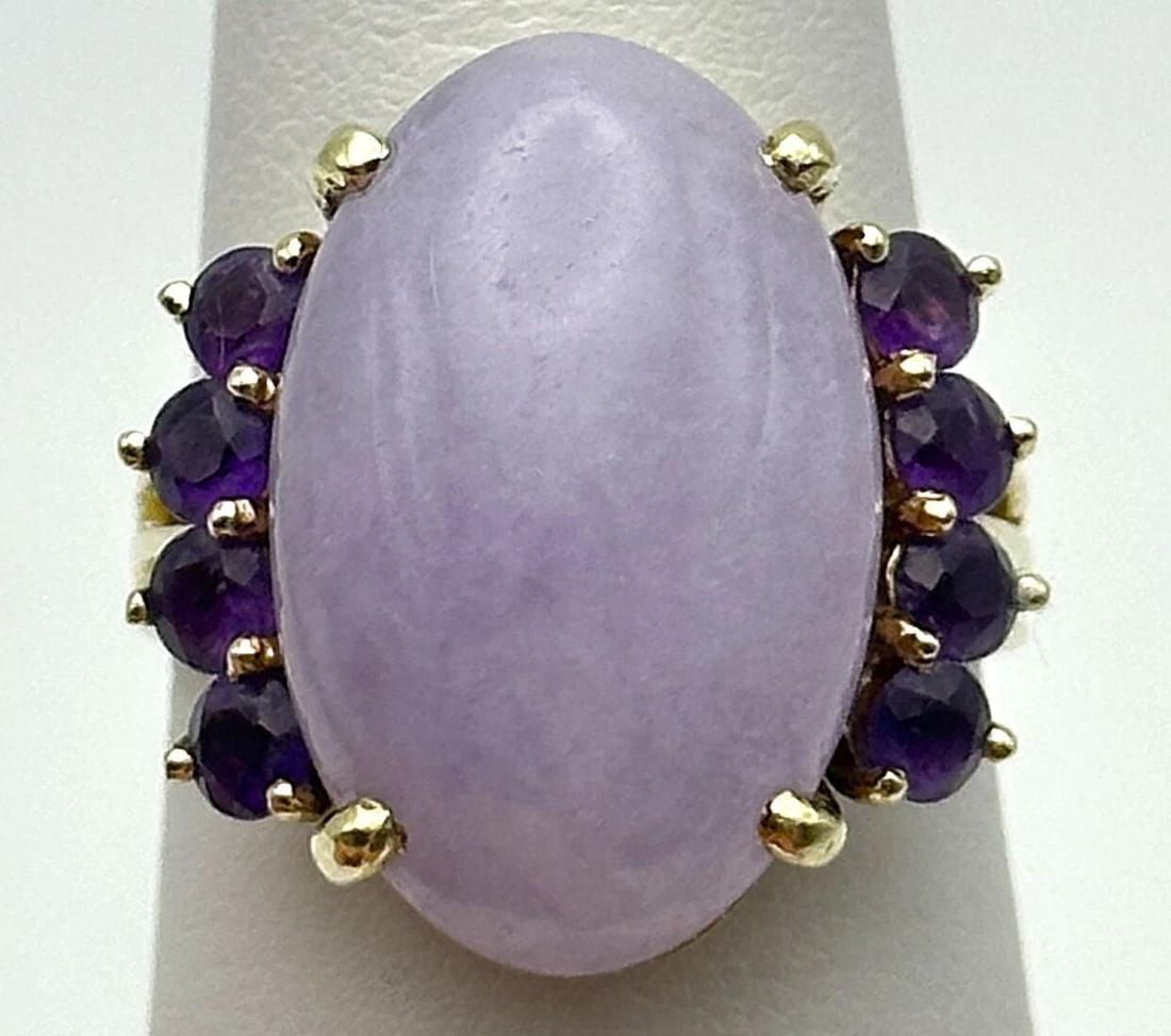 14K YELLOW GOLD RING WITH LAVENDER JADE AND AMETHYST (SIZE 7.25) 8.3 GRAMS: 14k Yellow Gold Ring with Lavender Jade and Eight Amethyst Stones Condition: Used, has marks and scratches on it Material: 14k Yellow Gold Ring Size: 7.25 Weight: 8.3 grams Top Width: 19mm Bottom Widt