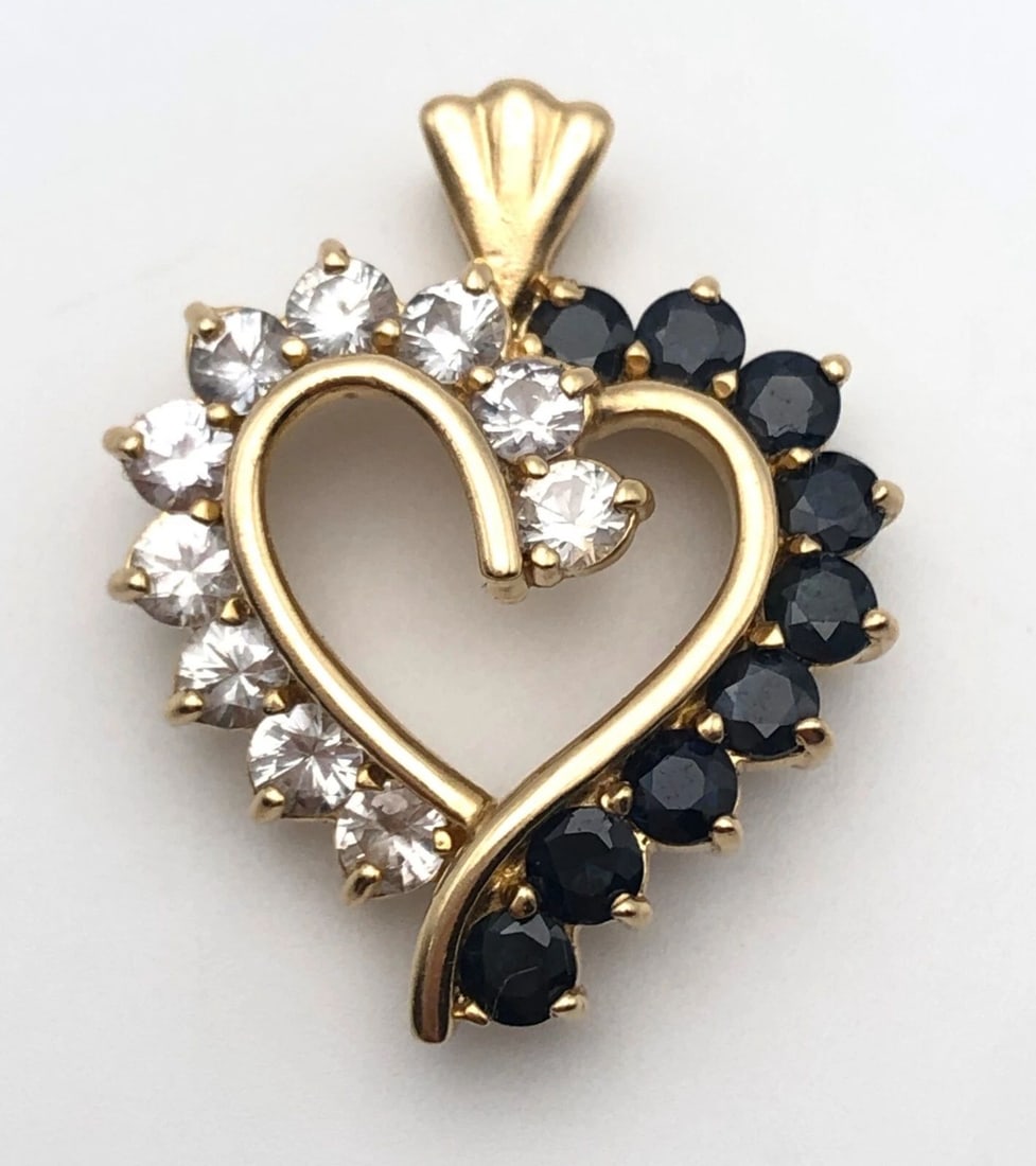 14K GOLD HEART PENDANT, 3.8CTS NATURAL WHITE/BLUE SAPPHIRES 4.9 GRAMS: 14K GOLD HEART PENDANT WITH 3.80CTS OF NATURAL WHITE/BLUE SAPPHIRES 4.9 GRAMS 14k Gold Heart Pendant set with 3.80cts of White and Blue Sapphires Condition: Used Material: 14k Yellow Gold Pendant Weig