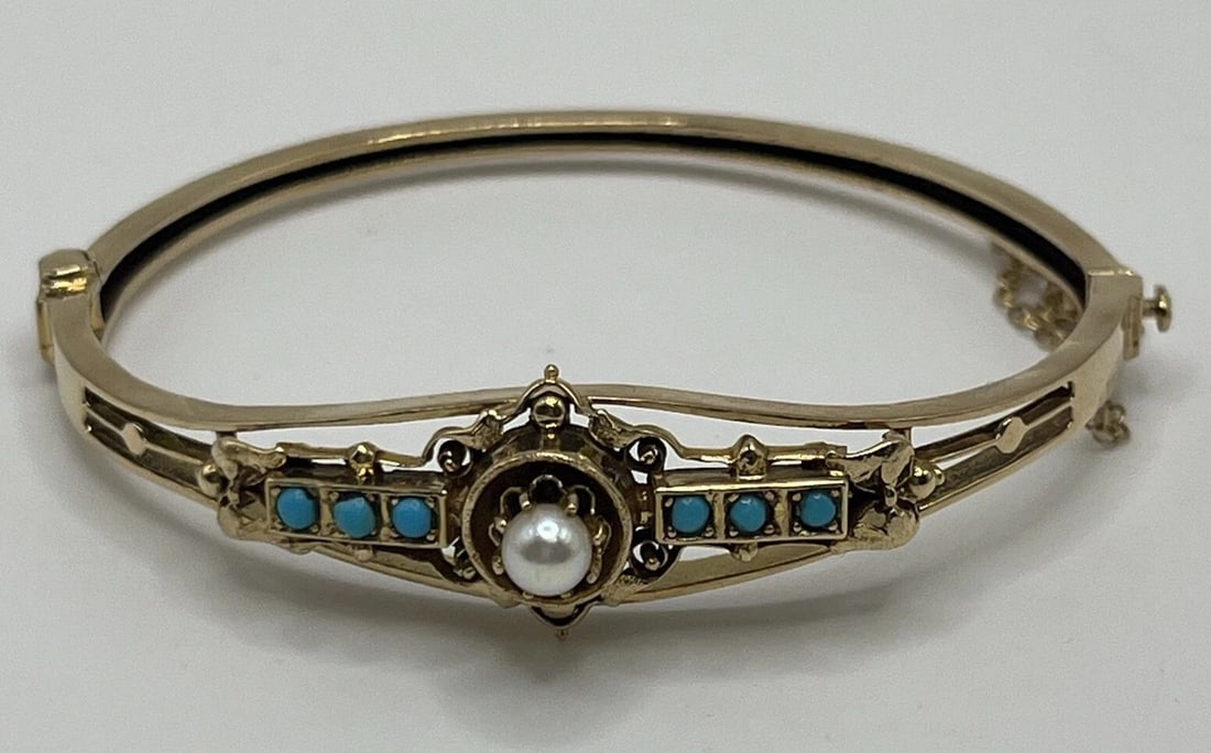 14 KT YELLOW GOLD BANGLE WITH 6 TURQUOISE STONES & 1 PEARL 14.7 GRAMS: 14 KT YELLOW GOLD BANGLE WITH 6 TURQUOISE STONES & 1 PEARL 14.7 GRAMS 14 KT YELLOW GOLD BANGLE WITH 6 TURQUOISE STONES & 1 PEARL 14.7 GRAMS Add a touch of elegance to your jewelry collection with this