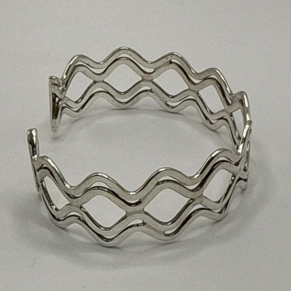 STERLING SILVER WAVE CUFF BRACELET 25 GRAMS: STERLING SILVER WAVE CUFF BRACELET 25 GRAMS STERLING SILVER WAVE CUFF BRACELET 25 GRAMS Crafted with elegance, this Sterling Silver Wave Cuff Bracelet is a timeless addition to any jewelry collection.