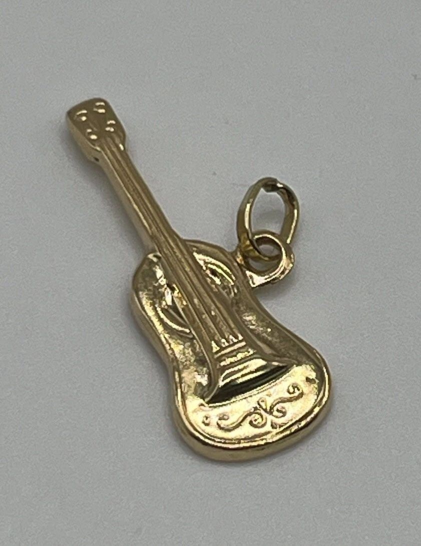 14K YELLOW GOLD GUITAR CHARM: 14K YELLOW GOLD GUITAR CHARM 14K YELLOW GOLD GUITAR CHARM Add some musical flair to your jewelry collection with this charming 14K yellow gold guitar pendant. Crafted with a base metal of yellow gold 