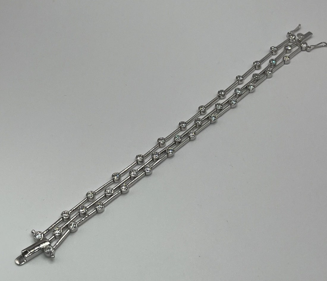 STERLING SILVER THREE STRAND TENNIS BRACELET WITH COLORLESS STONES 7": STERLING SILVER THREE STRAND TENNIS BRACELET WITH COLORLESS STONES 7" STERLING SILVER THREE STRAND TENNIS BRACELET WITH COLORLESS STONES 7" Elevate your jewelry collection with this stunning three