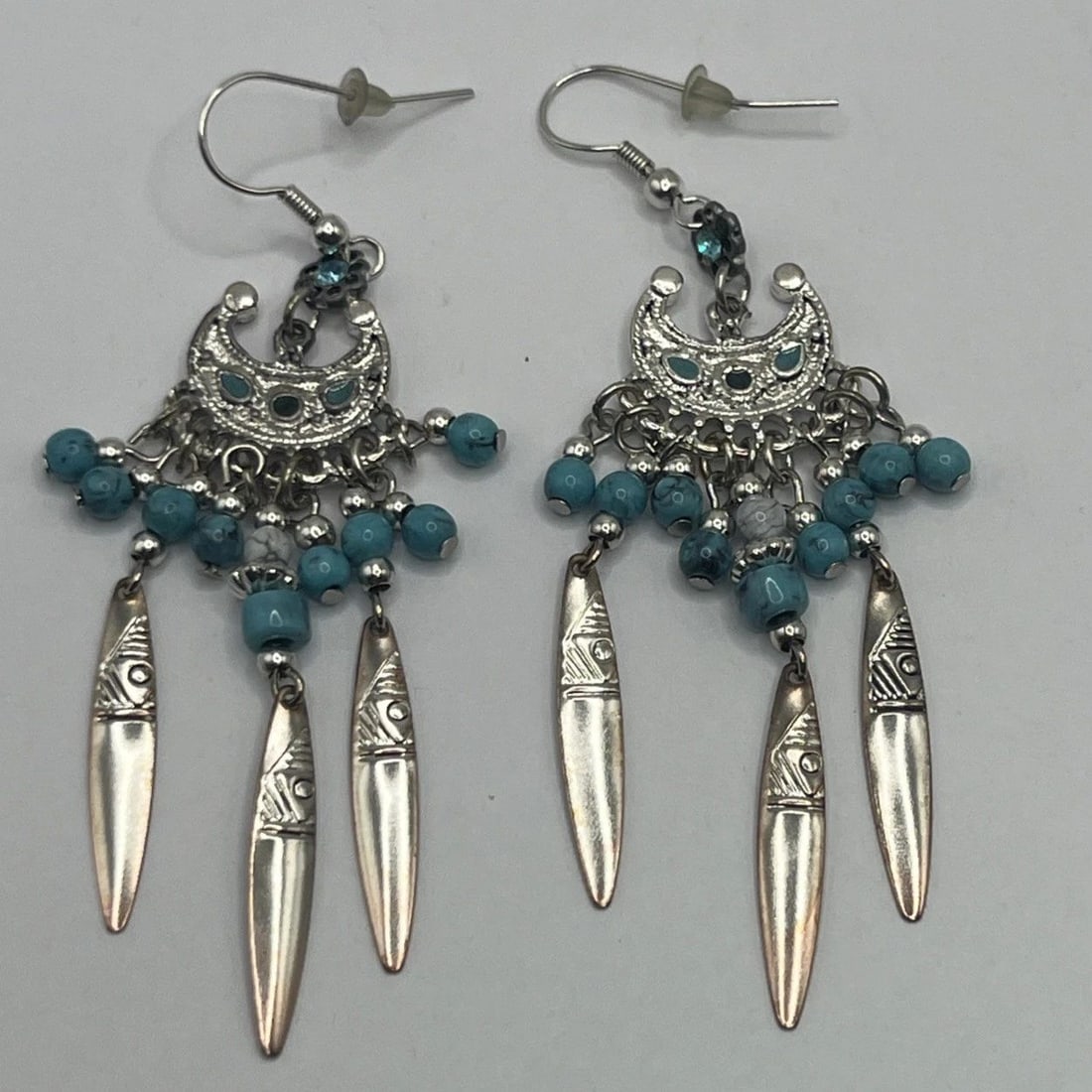 STERLING SILVER & TURQUOISE DANGLE EARRINGS: STERLING SILVER & TURQUOISE DANGLE EARRINGS STERLING SILVER & TURQUOISE DANGLE EARRINGS These Southwestern-inspired Sterling Silver Dangle Earrings feature a beautiful turquoise stone as the main focu