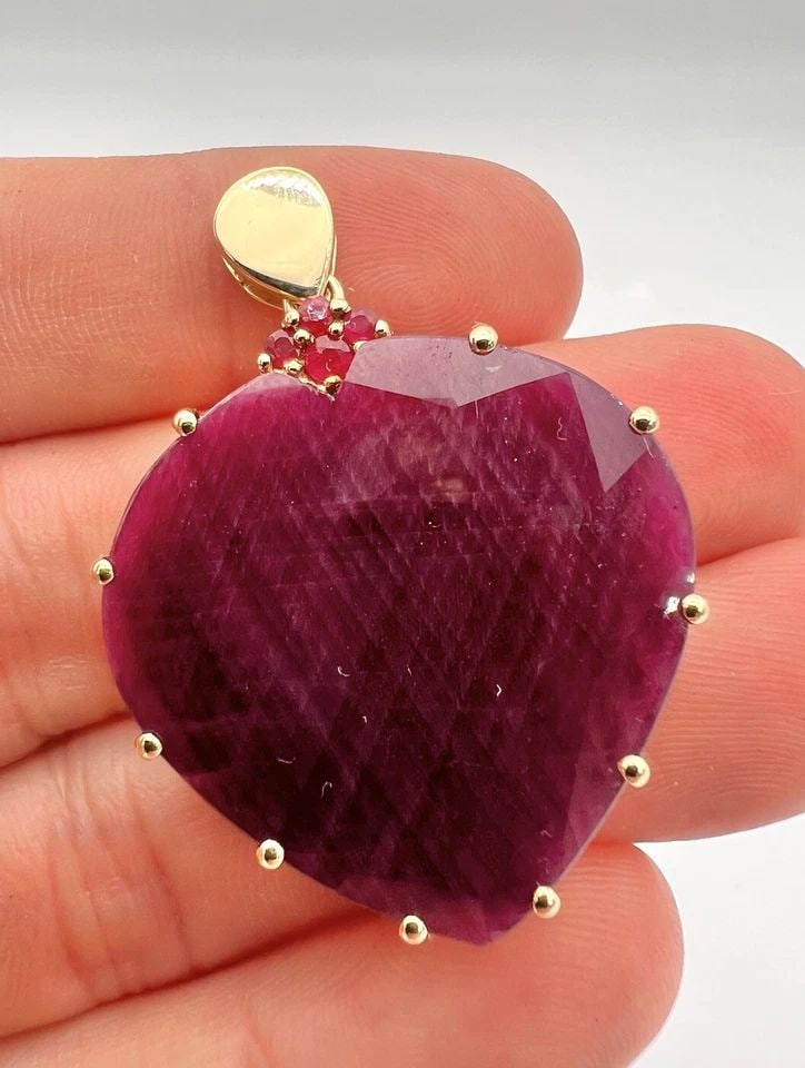 DESIGNER LARGE 40.00CT + HEART SHAPED RUBY 10K YELLOW GOLD PENDANT: DESIGNER LARGE 40.00CT + HEART SHAPED RUBY 10K YELLOW GOLD PENDANT DESCRIPTION Stunning Large Ruby Pendant, set in 10K Yellow Gold. Cent. Ruby Measurements: 30mm x 30mm - 3mm Cent. Ruby Weight: Approx
