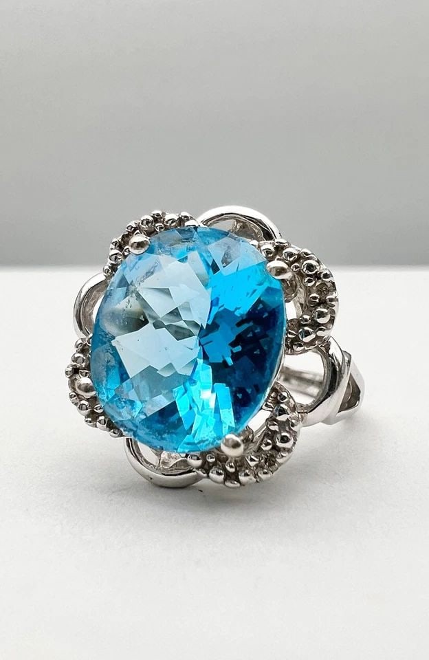 DESIGNER 10K WHITE GOLD NATURAL OVAL LONDON BLUE TOPAZ & DIAMOND RING: DESIGNER 10K WHITE GOLD NATURAL OVAL LONDON BLUE TOPAZ & DIAMOND RING Designer 10K White Gold Natural Oval London Blue Topaz & Diamond Ring Size: 9.25 - Can be Resized With Out Damage Weight is 4.5 Gr