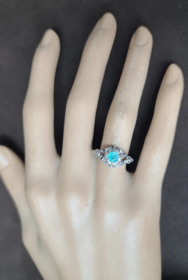 PLATINUM VINTAGE ENGAGEMENT RING 0.38CT.NATURAL BRAZIL PARAIBA TOURMALINE GIA: PLATINUM VINTAGE ENGAGEMENT RING 0.38CT.NATURAL BRAZIL PARAIBA ROUND TOURMALINE This Platinum Vintage Engagement Ring features a stunning 0.38ct. Natural Brazil Paraiba Tourmaline, certified by GIA. T