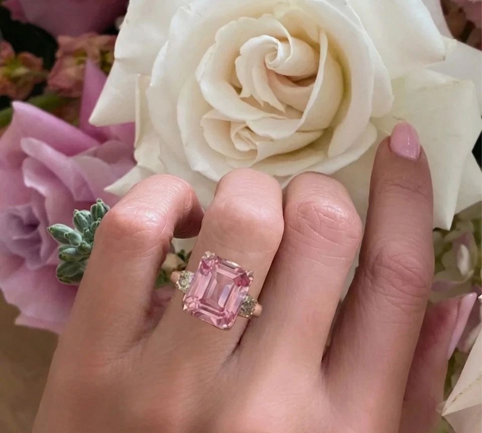 14K ROSE GOLD ENGAGEMENT RING 12.26CT. LAB GROWN PEACH SAPPHIRE EMERALD SHAPE: 14K ROSE GOLD ENGAGEMENT RING 12.26CT. LAB GROWN PEACH SAPPHIRE EMERALD SHAPE A stunning ring crafted in solid 14K rose gold, featuring a breathtaking emerald-cut lab-grown peach sapphire weighing app