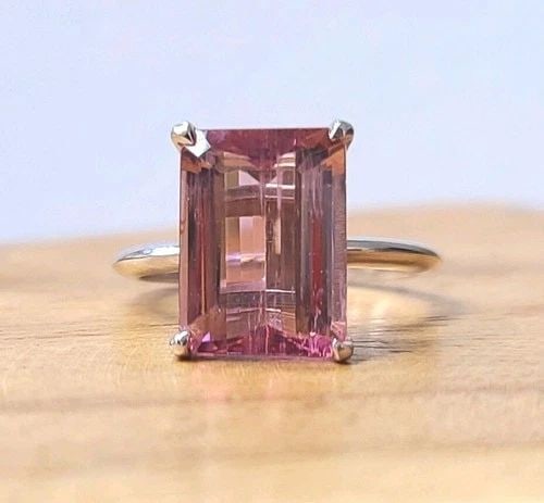 VINTAGE 14K WHITE GOLD ENGAGEMENT RING 5.27CT. NATURAL PINK TOURMALINE: VINTAGE 14K WHITE GOLD ENGAGEMENT RING 5.27CT. NATURAL PINK TOURMALINE This stunning 14k white gold ring features a breathtaking 5.27ct natural pink tourmaline in an emerald cut. The ring is perfect f