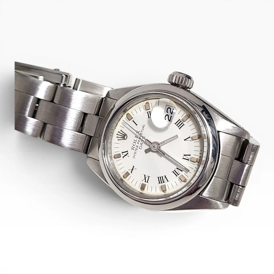 ROLEX LADIES DATE 26 MM WHITE ROMAN OYSTER STEEL AUTOMATIC WATCH 6916 CIRCA 1979: ROLEX LADIES DATE 26 MM WHITE ROMAN OYSTER STEEL AUTOMATIC WATCH 6916 CIRCA 1979 Manufacturer Rolex Category Oyster Perpetual Ladies Date Reference Number 6916 Band Stainless Steel Band Color Steel Ba