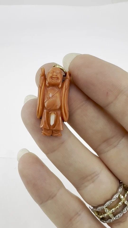 VINTAGE CORAL BUDDHA CHARM PENDANT 10K GOLD: VINTAGE CORAL BUDDHA CHARM PENDANT 10K GOLD KL GOO Vintage coral Buddha charm carved in natural coral and mounted in 10k gold. The figure is flat-backed and secured to a gold plate, with a fixed gold 
