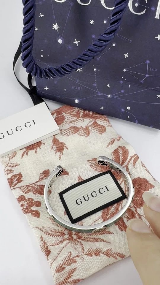 GUCCI STERLING SILVER ENAMEL INTERLOCKING G CUFF BRACELET: GUCCI STERLING SILVER ENAMEL INTERLOCKING G CUFF BRACELET KL AOO This Gucci sterling silver enamel cuff bracelet highlights the brand’s signature craftsmanship and bold design. The bracelet is craft