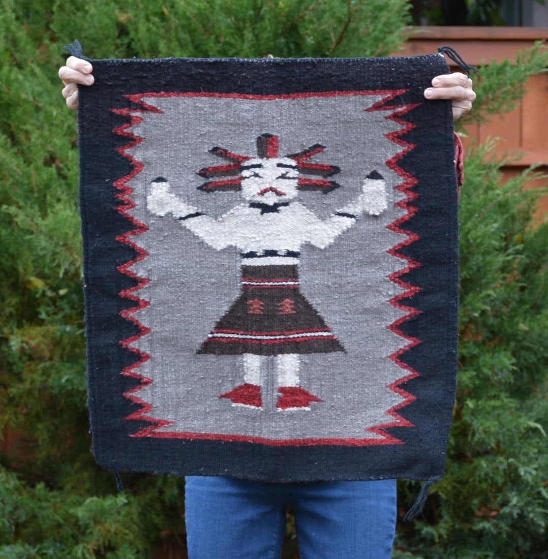 VINTAGE NAVAJO RUG - PICTORIAL - SINGLE YEI FIGURE - FEATHERS - 25.5" X 23": VINTAGE NAVAJO RUG - PICTORIAL - SINGLE YEI FIGURE - FEATHERS - 25.5" X 23" This Navajo rug shows an unusual Yei figure with a headress wearing mocassins and holding feathers. This rug measures 25.5" 