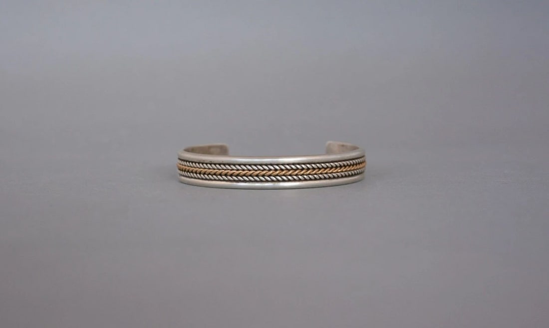 VINTAGE NAVAJO STERLING SILVER WITH 12 KT.GF GOLD BRACELET 3/8" BAND - SIZE 7": VINTAGE NAVAJO STERLING SILVER WITH 12 KT.GF GOLD BRACELET 3/8" BAND - SIZE 7" This bracelet has been beautifully crafted by Navajo silversmith Daniel Mike. It has 2 rows of twisted sterling silver wi