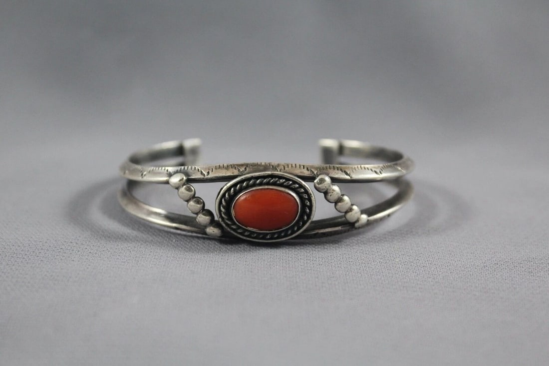 OLD PAWN NAVAJO STERLING SILVER AND CORAL BRACELET: OLD PAWN NAVAJO STERLING SILVER AND CORAL BRACELET Item Description: This bracelet measures 1/2 " wide at the center front. The size is 5" around the inside with an additional 1 1/4" opening at the ba
