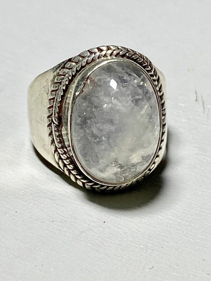 MOONSTONE RING CIGAR BAND WOMEN STERLING SILVER SIZE 7.50: MOONSTONE RING CIGAR BAND WOMEN STERLING SILVER SIZE 7.50 Moonstone ring cigar band women sterling silver An imperfection on the edge of the stone- slight chip - and setting there curves in to reflect