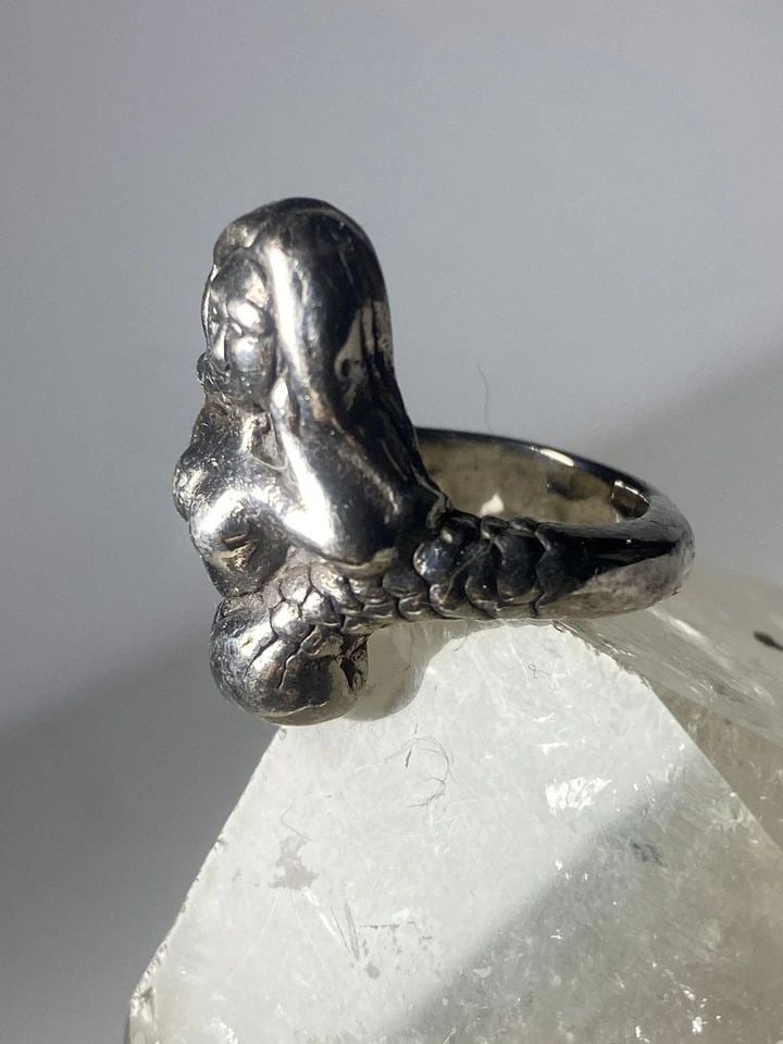 MERMAID RING FIGURATIVE BAND STERLING SILVER WOMEN: MERMAID RING FIGURATIVE BAND STERLING SILVER WOMEN Mermaid ring figurative band sterling silver women A light weight hollow ring Size 7 Weight 3.7g Widest part 1" Thinnest part of band in back 5/32"