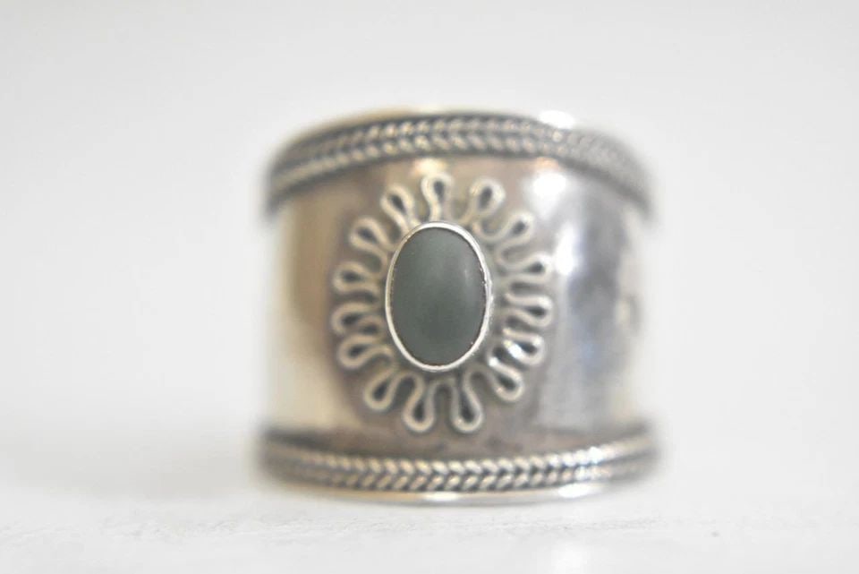 CIGAR BAND SIZE 7.25 GREEN STONE RING STERLING SILVER WOMEN: CIGAR BAND SIZE 7.25 GREEN STONE RING STERLING SILVER WOMEN Cigar Band green stone ring sterling silver women ***minor dent**** Size 7.25 Weight 3.2g Widest part of band 3/4" Thinnest part of band 7/3