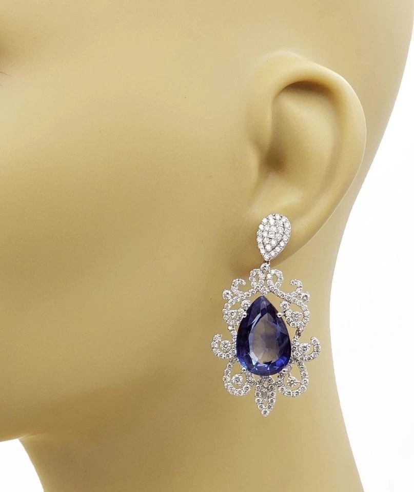 DIAMOND EARRINGS BLUE STONE 18K WHITE GOLD FLORAL DANGLE ESTATE: DIAMOND EARRINGS BLUE STONE 18K WHITE GOLD FLORAL DANGLE ESTATE These floral dangle earrings feature blue stone set in 18k white gold. The diamonds and gemstones add a touch of elegance to the design,