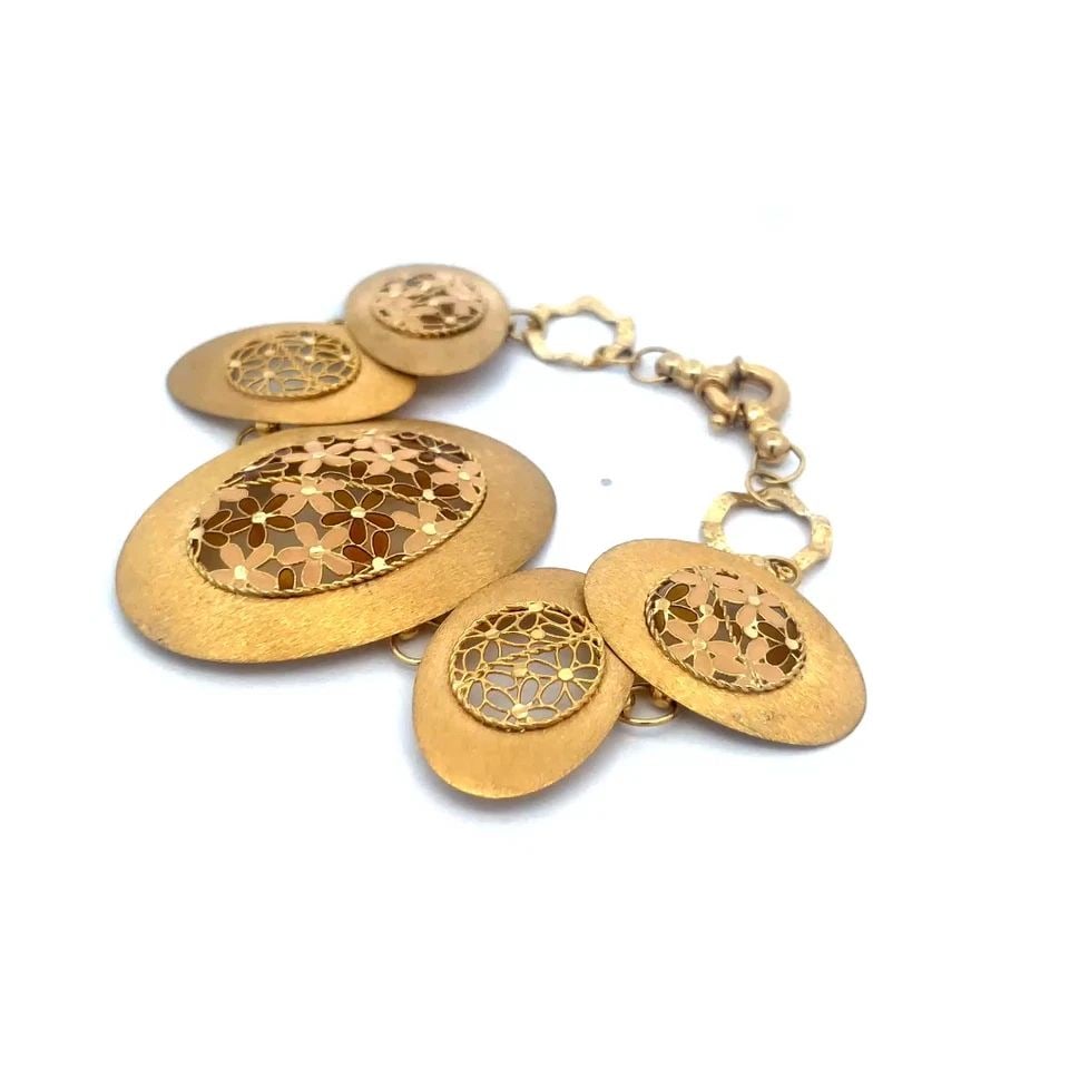 VINTAGE FLORAL GOLD BRACELET 14K YELLOW ENAMEL OVAL DISC LINKS: This lovely vintage bracelet is crafted from 14k yellow gold featuring large and small oval discs with detailed open style floral filigree style work set in the center of each link, the flowers are en
