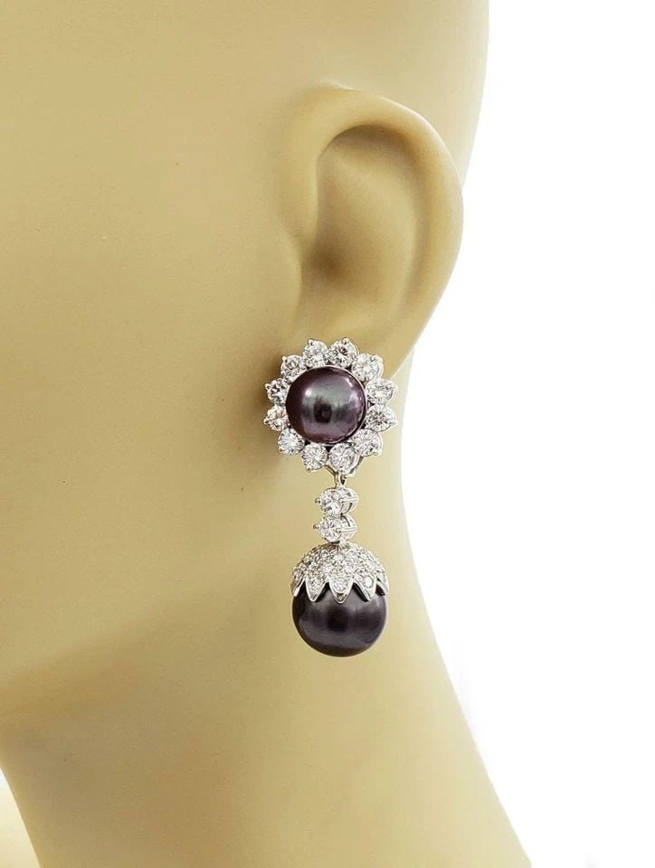 EARRINGS DIAMOND & SOUTH SEA PEARLS 14K WHITE GOLD FLORAL DANGLE: EARRINGS DIAMOND & SOUTH SEA PEARLS 14K WHITE GOLD FLORAL DANGLE These earrings are crafted with 14k white gold and feature a beautiful floral design with round south sea pearls and sparkling diamonds