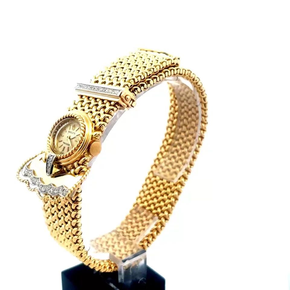 ROLEX GOLD LADIES WATCH 18K YELLOW DIAMOND MESH BELT BUCKLE STYLE MANUAL: The gorgeous Rolex ladies wristwatch is a luxurious timepiece crafted with 18k yellow gold, featuring a lovely intricate woven mesh belt with a diamond accented wide bar buckle style closure. This vin