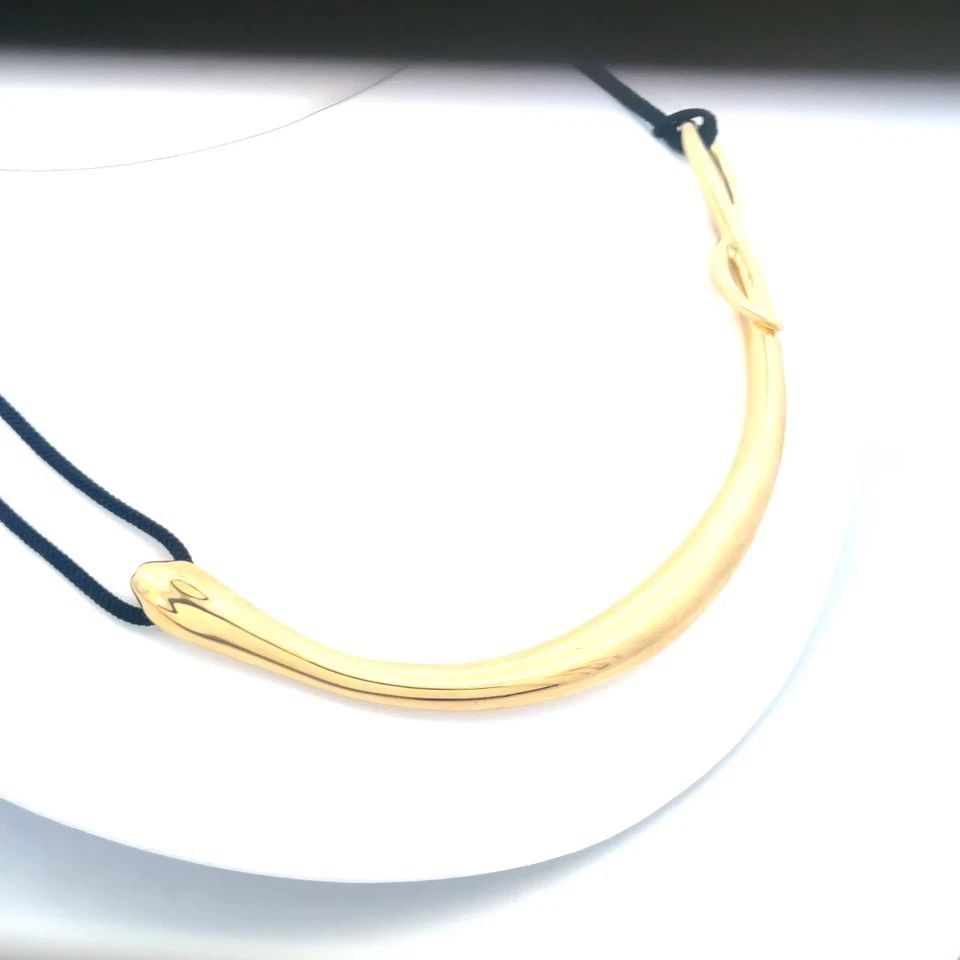 TIFFANY & CO. GOLD SNAKE PENDANT PERETTI 18K YELLOW BLACK CORD PAPER: TIFFANY & CO. GOLD SNAKE PENDANT PERETTI 18K YELLOW BLACK CORD PAPER This is an eye-catching authentic early edition collar necklace from Tiffany & Co., by designer Elsa Peretti, this particular desig