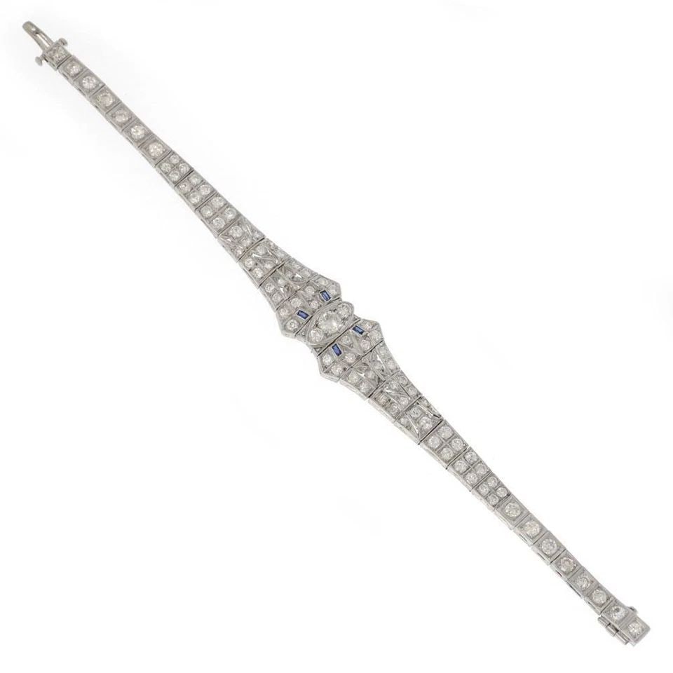 DIAMOND PLATINUM BRACELET TAPERED MILGRAIN DESIGN ART DECO: DIAMOND PLATINUM BRACELET TAPERED MILGRAIN DESIGN ART DECO This Diamond Platinum Bracelet features a tapered milgrain design in an Art Deco style. The vintage piece is adorned with blue gemstones and 