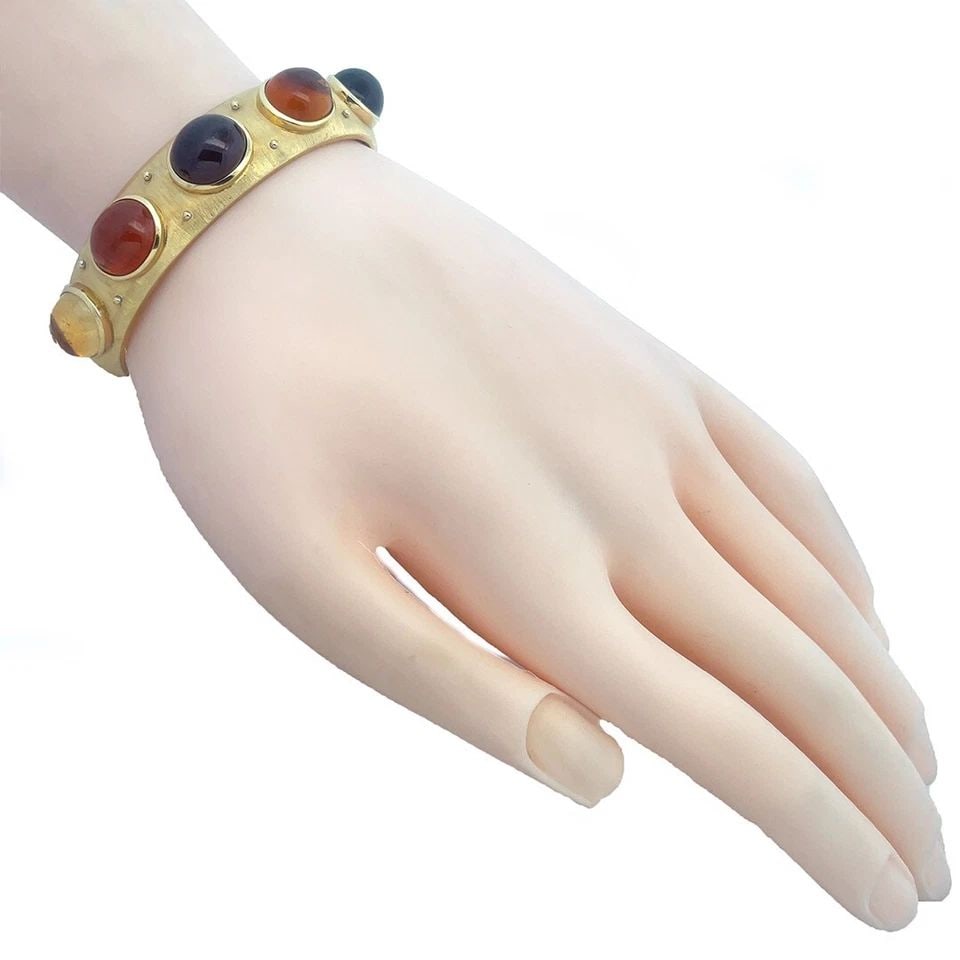 GOLD 18K CUFF BRACELET YELLOW MULTICOLOR GEMS LARGE OVAL CABOCHON STYLE: GOLD 18K CUFF BRACELET YELLOW MULTICOLOR GEMS LARGE OVAL CABOCHON STYLE This is a beautiful 18k yellow gold cuff bracelet with a fine brush finish. The front part of the 14.5mm wide band has 5 bezel s