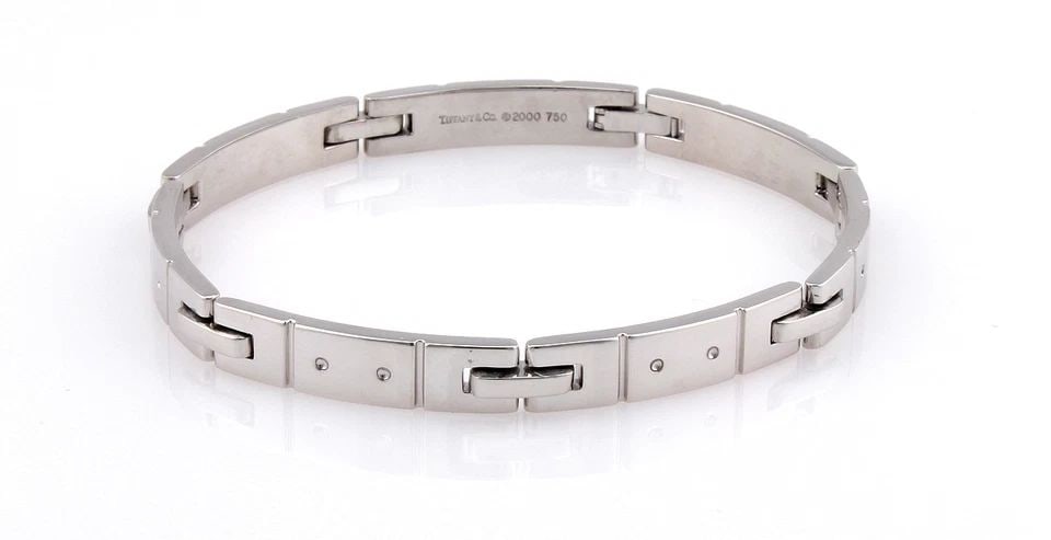 TIFFANY & CO. DIAMOND GOLD BRACELET 18K WHITE GOLD RECTANGLE FLAT LINK: TIFFANY & CO. DIAMOND GOLD BRACELET 18K WHITE GOLD RECTANGLE FLAT LINK The Tiffany & Co. Diamond Gold Bracelet is a stunning piece of fine jewelry crafted from 18K white gold. It features a sleek rect