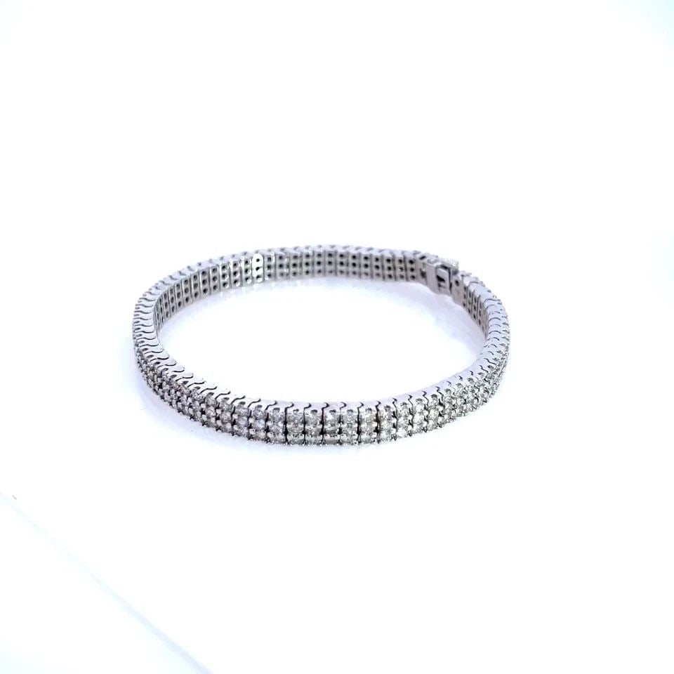 DIAMOND TENNIS BRACELET 14K WHITE GOLD TRIPLE ROW 6MM WIDE: DIAMOND TENNIS BRACELET 14K WHITE GOLD TRIPLE ROW 6MM WIDE The Diamond Tennis Bracelet is a luxurious and elegant piece of jewelry crafted from 14k white gold. This triple row bracelet features round-